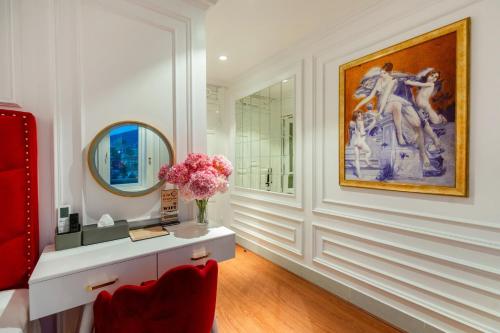 La salle de bains est pourvue d'une peinture murale et d'un vase de fleurs. dans l'établissement Diamond Hotel Sapa, à Sa Pa