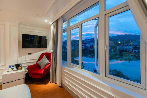 a room with a red chair and a large window at Diamond Hotel Sapa in Sa Pa