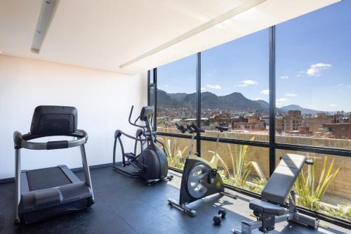 a gym with a large window with a view of a city at Cassa Luxury Homes in Bogotá