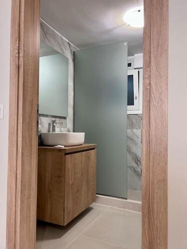 a bathroom with a sink and a mirror at Minimal Cozy Apartment in Mytilini