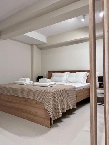 1 dormitorio con 1 cama grande con almohadas blancas en Minimal Cozy Apartment, en Mytilini