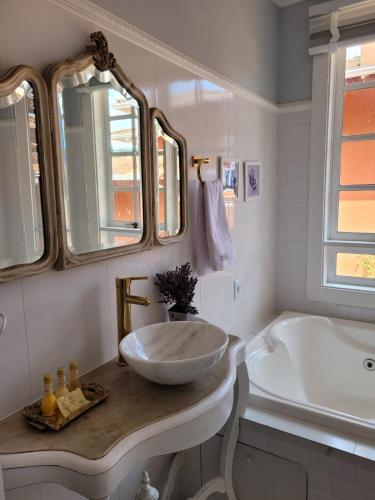 a white bathroom with a sink and a tub at La Belle Provence in Itaipava