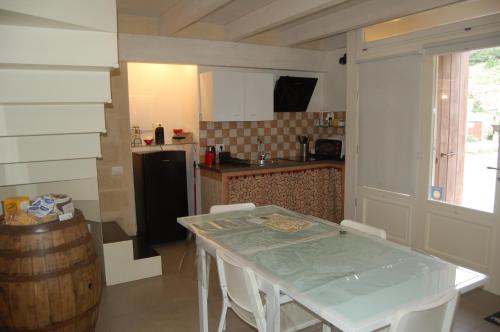 a kitchen with a table and chairs and a refrigerator at Le 2 Gravine nei Sassi in Matera