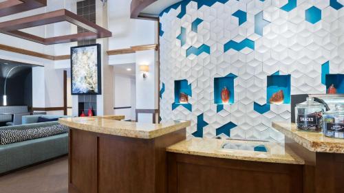 um átrio com um balcão de recepção com azulejos azuis e brancos em Hyatt Place Boston/Medford em Medford
