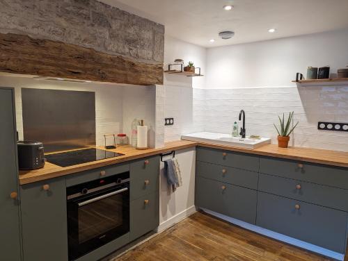 une cuisine avec un évier et une cuisinière four supérieur dans l'établissement Maison de Bourg Cressensac, à Cressensac