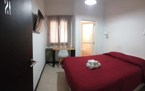 a bedroom with a red bed with a stuffed animal on it at Sur Hotel in Necochea