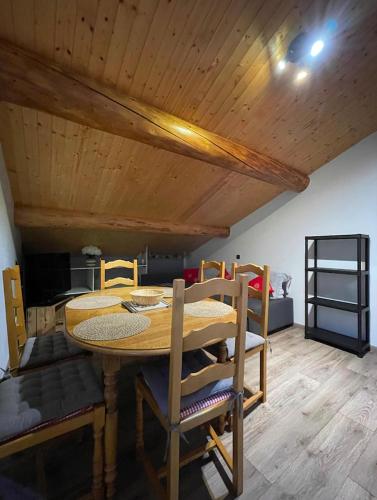 une salle à manger avec une table et des chaises en bois dans l'établissement Appartement Chalet Petzu - 6 Pers - Parking - Ski au pied, à Levassaix