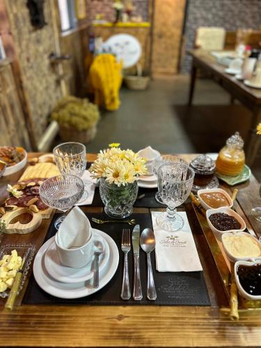 a table with plates and silverware on top of it at Glamping montain experience in São Joaquim