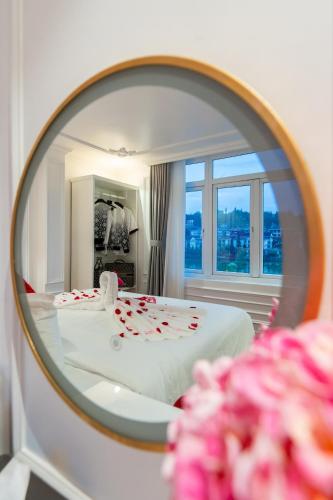 a mirror reflecting a bedroom with a bed with roses on it at Diamond Hotel Sapa in Sapa