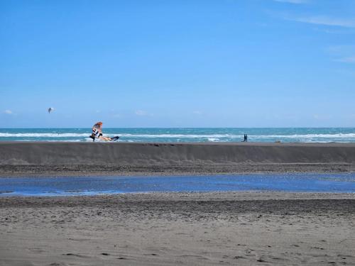 uma pessoa sentada na praia perto do oceano em Lodge Los Bosques em Matanzas