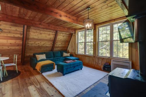 a living room with a blue couch in a log cabin at Private Pocono Getaway with Hot Tub and Sauna! in East Stroudsburg