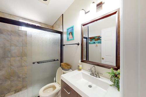 La salle de bains est pourvue d'un lavabo, de toilettes et d'un miroir. dans l'établissement Amada Grenada, à Summerland Key