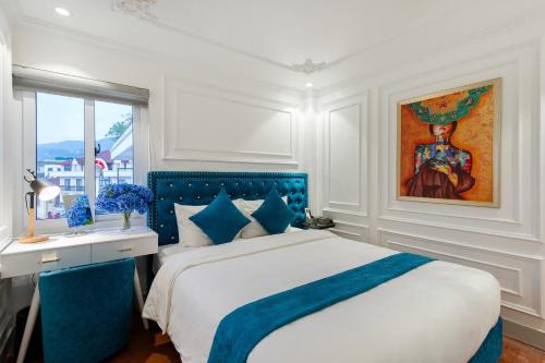 a bedroom with a bed and a desk and a window at Diamond Hotel Sapa in Sapa