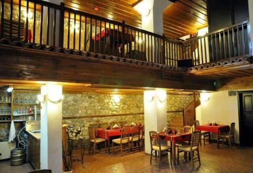 a restaurant with tables and chairs and a balcony at Хотел Свети Никола in Melnik