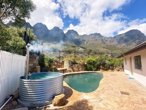 a swimming pool with mountains in the background at Mountain Oasis Villa, Pool,Hot Tub, Inverter in Cape Town