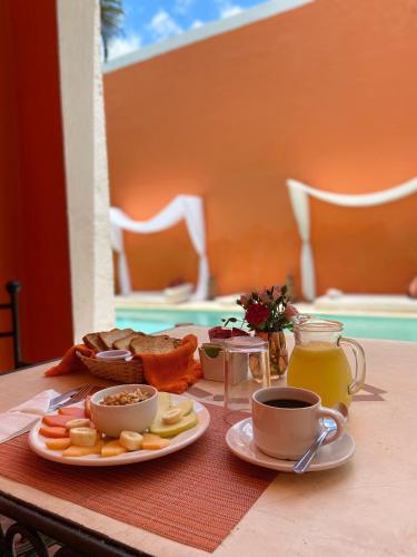 een tafel met een bord eten en kopjes koffie bij Art 64 Hotel Boutique - Adults Only in Mérida
