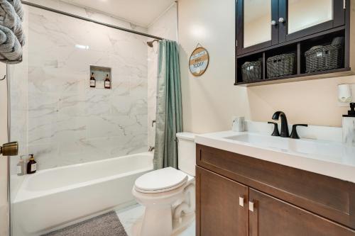 a bathroom with a toilet and a tub and a sink at Charming Boho Home Near OSU, Short North, Downtown in Columbus
