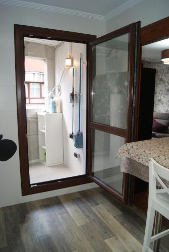 a sliding glass door in a room with a refrigerator at BEC, Hospital Cruces, parking gratis, wifi, AA, a 15 min de Bilbao in Barakaldo