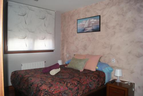 Un dormitorio con una cama con almohadas. en BEC, Hospital Cruces, parking gratis, wifi, AA, a 15 min de Bilbao, en Barakaldo