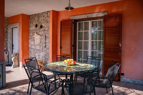 a table with a bowl of fruit on a patio at Villa Rita Taormina in Taormina