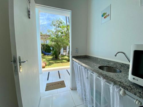 uma cozinha com um lavatório e uma porta para um quintal em Casa da Praia Juquehy JQY em Juquei