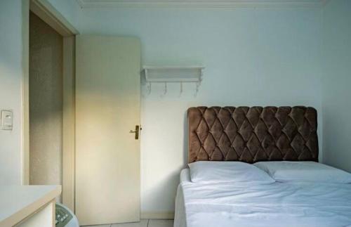 a bedroom with a large bed with a brown headboard at Residencial Primavera in Balneário Camboriú