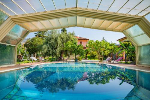 an indoor swimming pool with a large ceiling and a large swimming pool at Villa Rita Taormina in Taormina