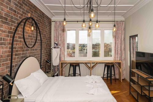 een slaapkamer met een wit bed en een bakstenen muur bij Heart of the City Center Lux Apartment with View in Sofia