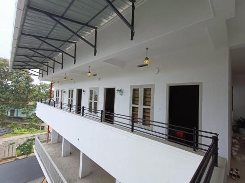 ein leeres Gebäude mit weißen Wänden und einem Balkon in der Unterkunft SN Residency in Kalpatta