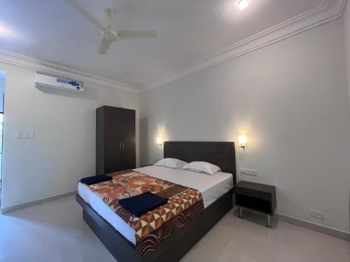 a bedroom with a bed and a ceiling fan at Morjim Sunset Guesthouse- Apartments with Kitchen & AC Rooms in Morjim