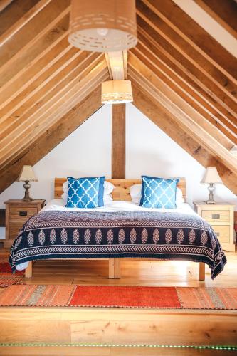 a bed with blue pillows in a attic at the garden room in Shrewsbury