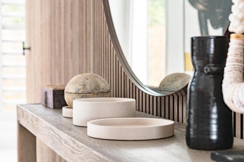 a shelf with a mirror and some vases on it at VILLA KARAMISO - Piscine à débordement & Vue sur mer - Accès Plage in Saint-François