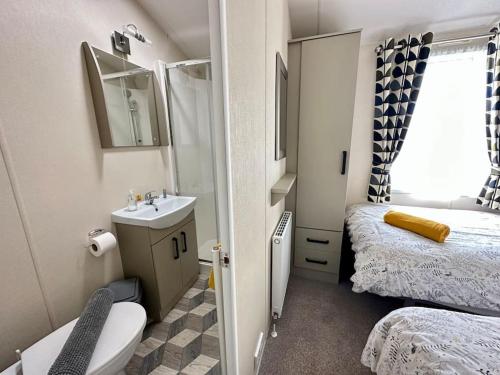 a small bathroom with a toilet and a sink at Spring View Hot tub Lodge in South Cerney