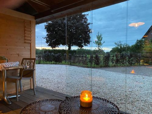 een patio met een tafel en een groot glazen raam bij B&B Bergheide in Baexem