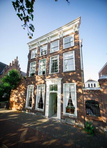 un antiguo edificio de ladrillo con una puerta verde en Boutique Hotel Museumkwartier en Utrecht