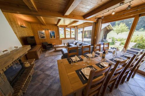 Chalet Haut Fort Ski Injacuzzi في مورزين: غرفة طعام مع طاولة وكراسي طويلة