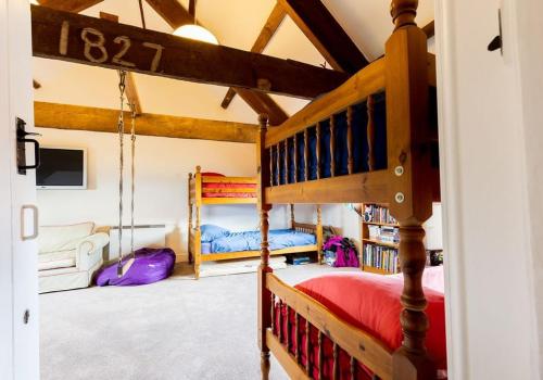 un dormitorio con una cama y una litera en Parrog Beach House - Sleeps 12, en Pembrokeshire
