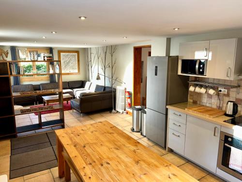 uma cozinha e sala de estar com um frigorífico e uma mesa em The Castle, 10 Bedroom Chalet, Chamonix Centre em Chamonix-Mont-Blanc