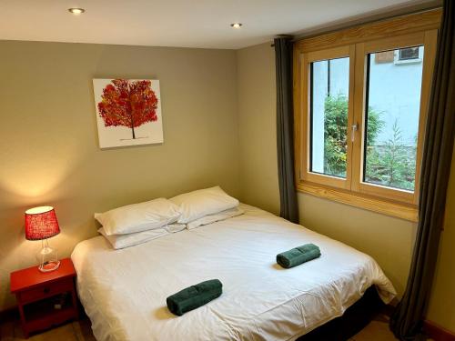 - une chambre avec un lit avec deux oreillers et une fenêtre dans l'établissement The Castle, 10 Bedroom Chalet, Chamonix Centre, à Chamonix-Mont-Blanc