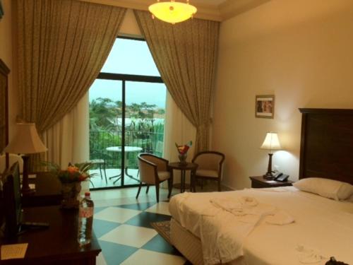 pokój hotelowy z łóżkiem i dużym oknem w obiekcie Atlantic Palace Hotel w mieście Pointe-Noire