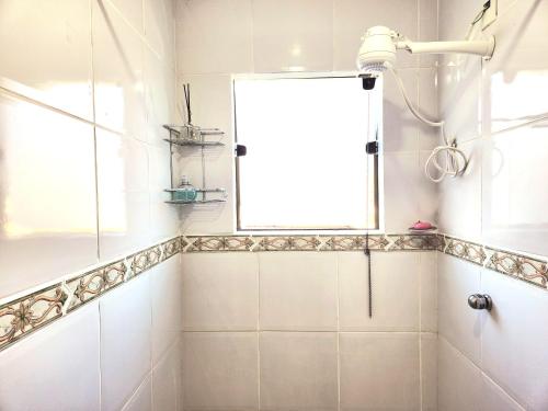 a bathroom with a shower and a window at PousaDinháChica Hospedagem perto de Tiradentes Minas Gerais in São João del Rei
