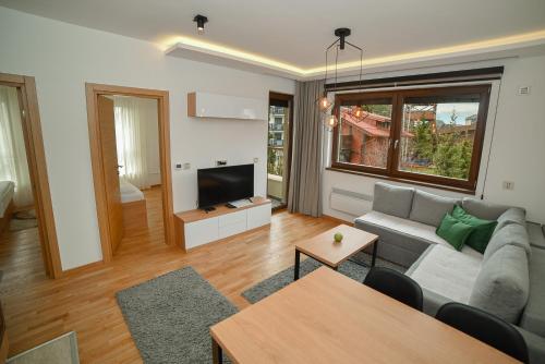 a living room with a couch and a tv at Aria Club Wellness&Spa Zlatibor in Zlatibor