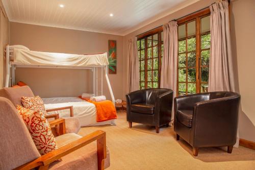a bedroom with a bed and two chairs at Mount Park Guest Farm in Dargle