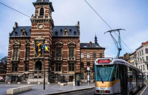 a train in front of a building with a clock tower at One bedroom appartement with wifi at Anderlecht in Brussels