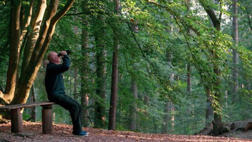 a man sitting on a bench taking a picture at Molecaten Park De Leemkule in Hattem