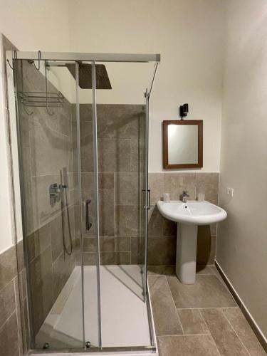 a bathroom with a glass shower and a sink at Baroon Bistrot & Rooms in Polizzi Generosa