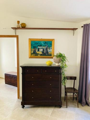 a bedroom with a dresser and a painting on the wall at Baroon - Bistrot & B&B in Polizzi Generosa