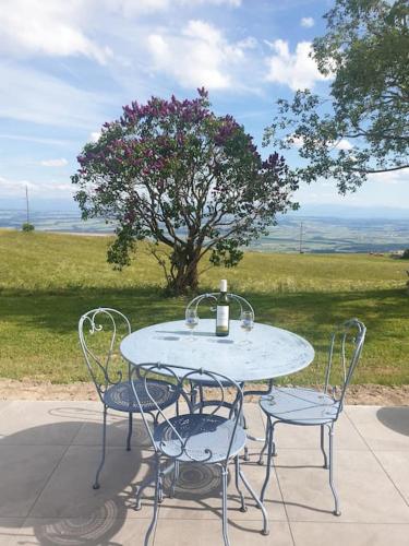 a table with two chairs and a bottle of wine on it at Coup d'œil in Bullet