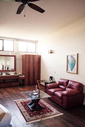 a living room with a couch and a table at La Buena Vibra Retreat and Spa Hotel in Tepoztlán