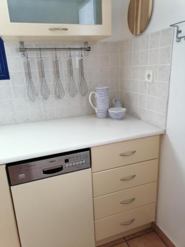 a kitchen with a white counter top with a dishwasher at HONES - RELAX HOUSE in Perissa